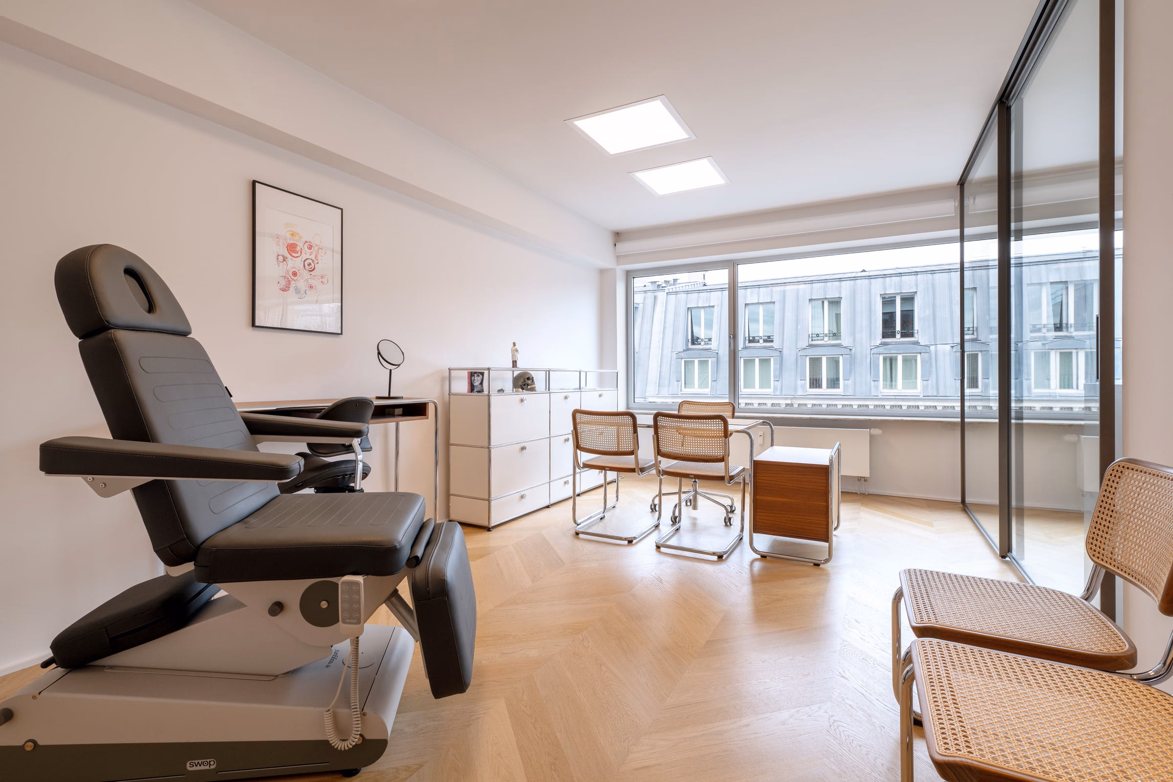 A room with a chair, a desk and a picture on the wall