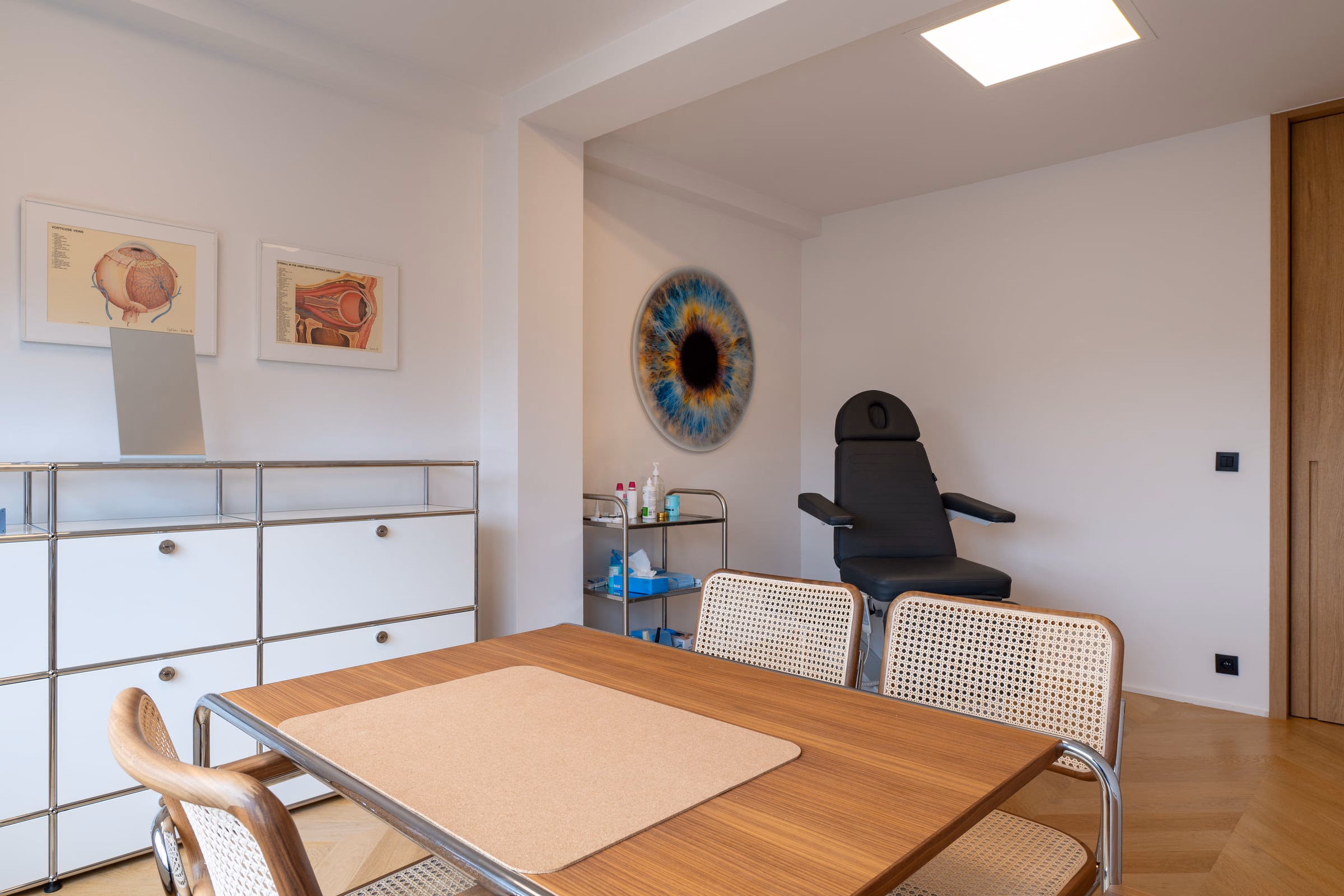 A room with a table, chairs and a painting on the wall