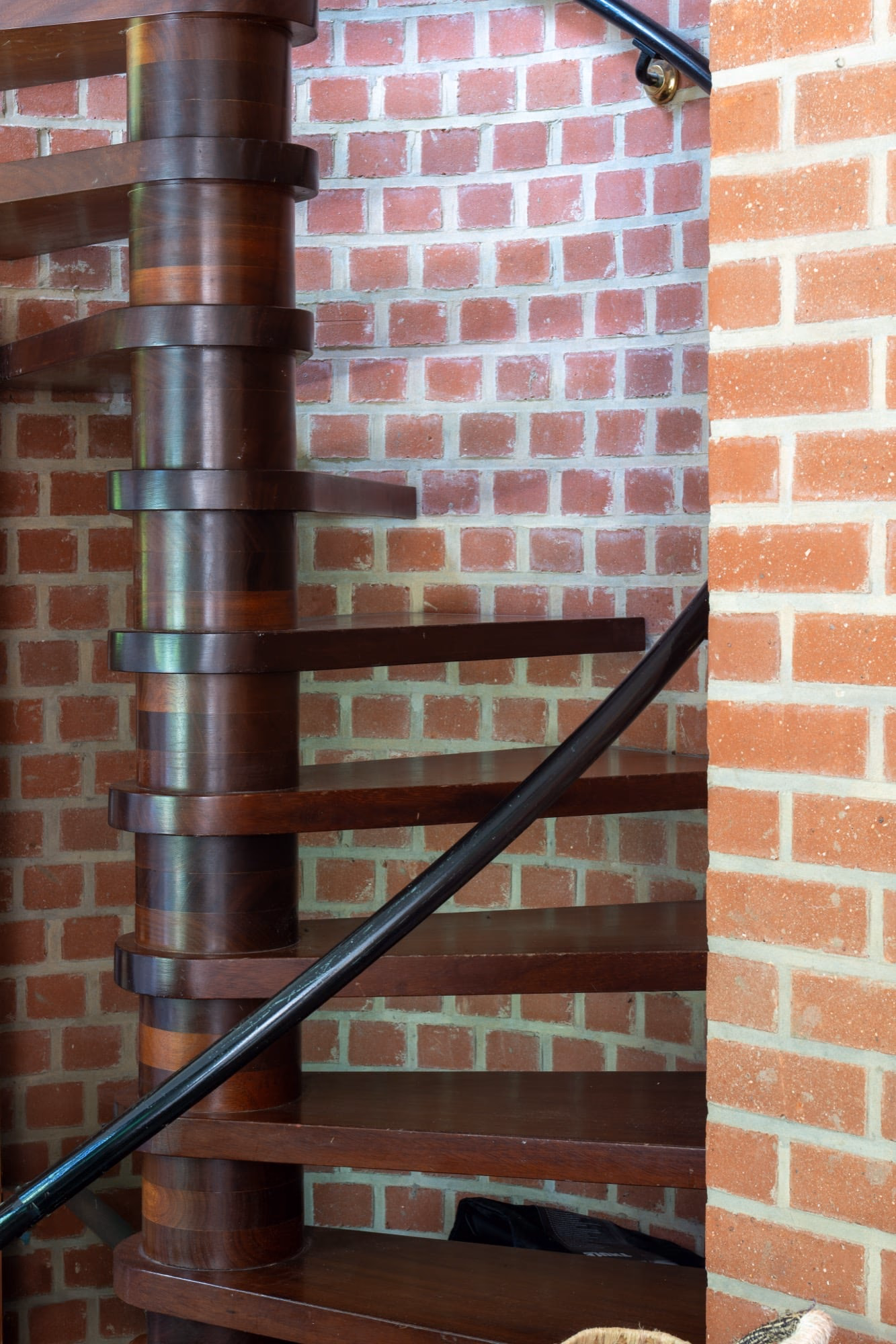 A spiral staircase in front of a brick wall