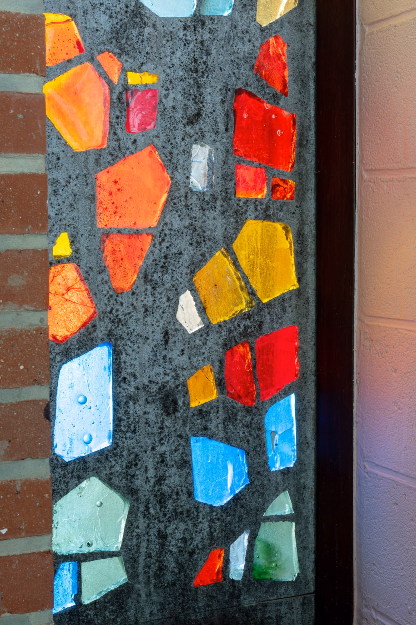 A stained-glass window set in a brick wall
