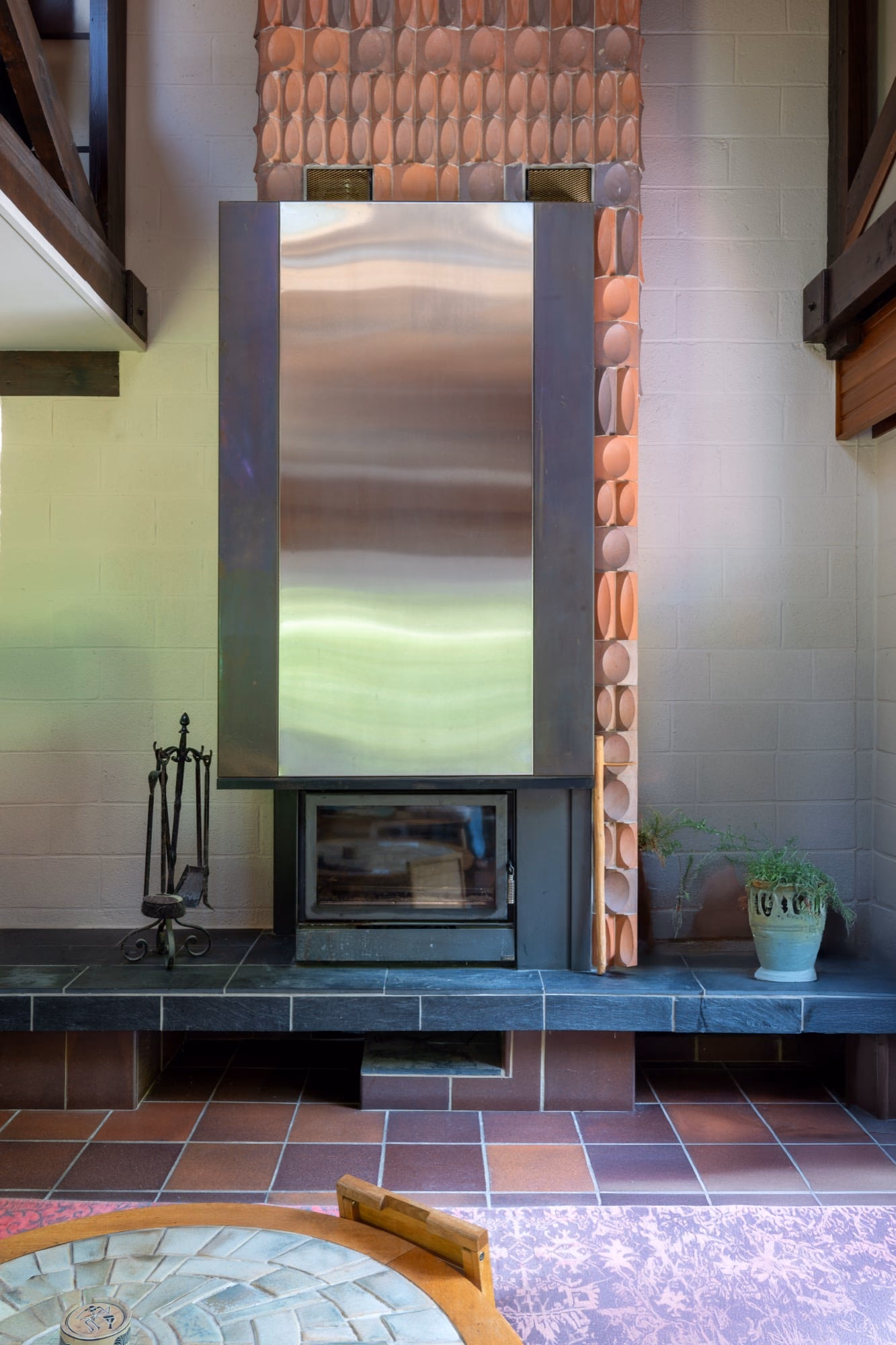 A fireplace with a potted plant in front