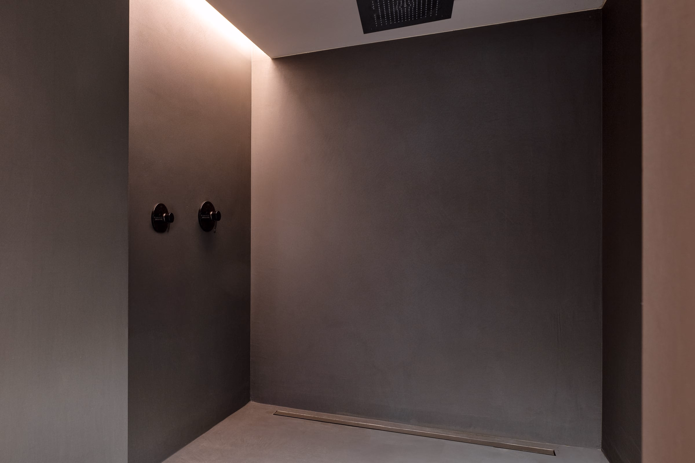 A dark room with two black knobs on the wall