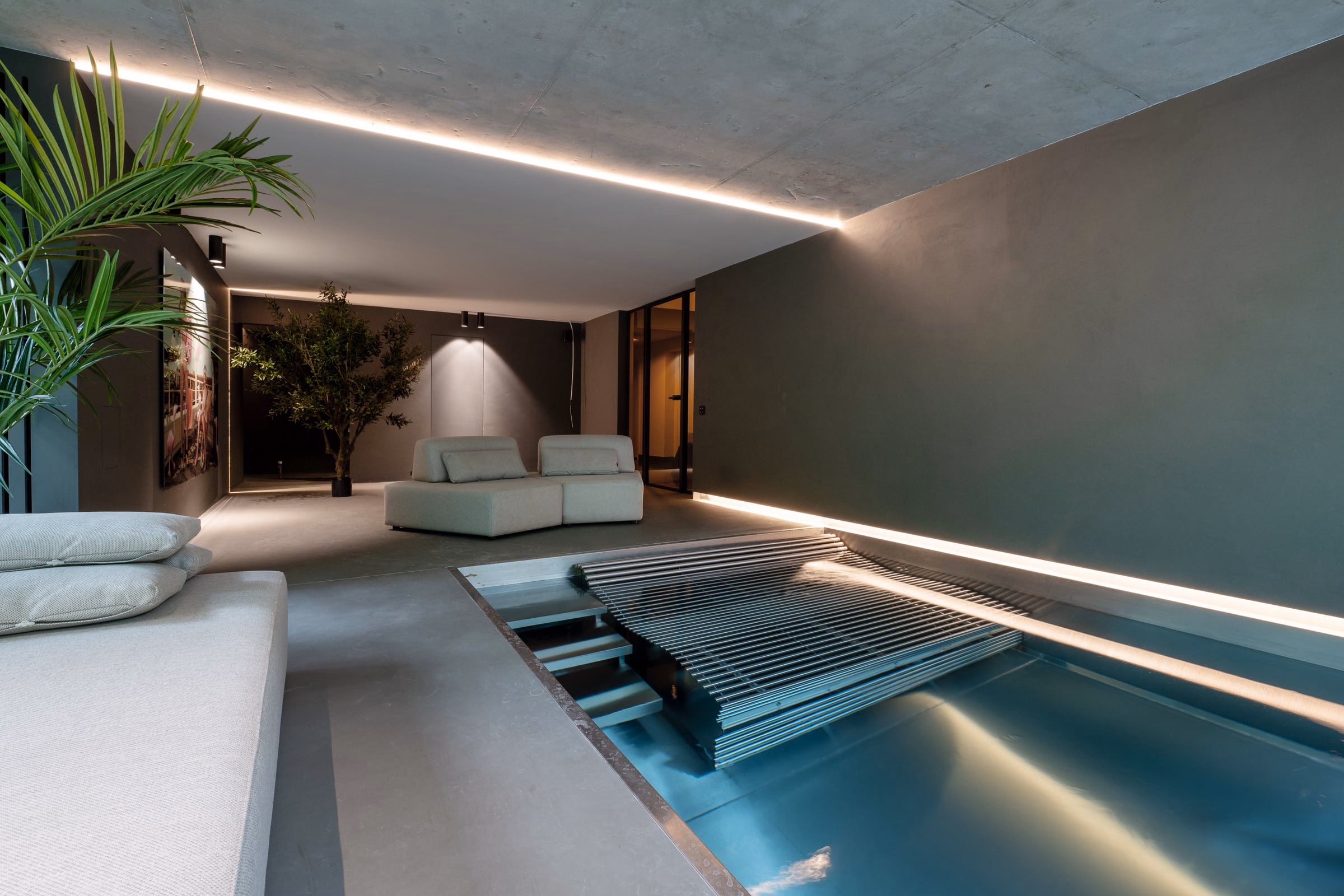An indoor pool beneath a lit concrete ceiling
