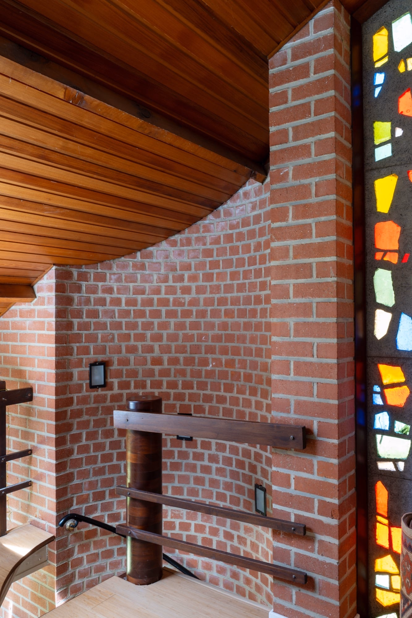 A brick wall with a stained-glass window behind it