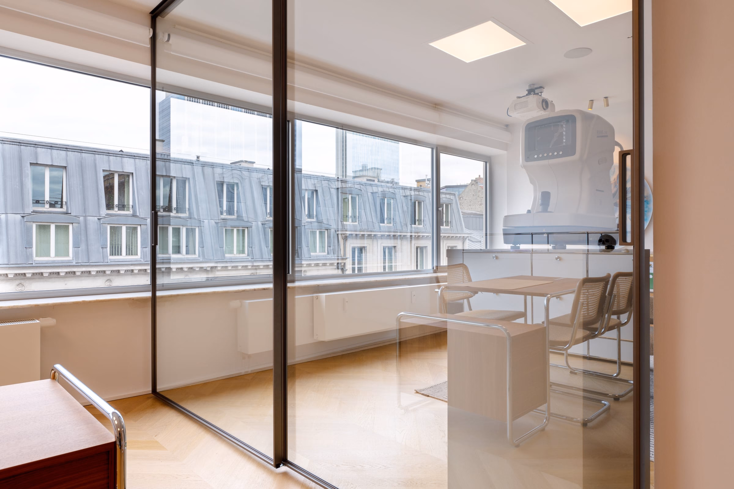 A room with a table, chairs and a ceiling projector
