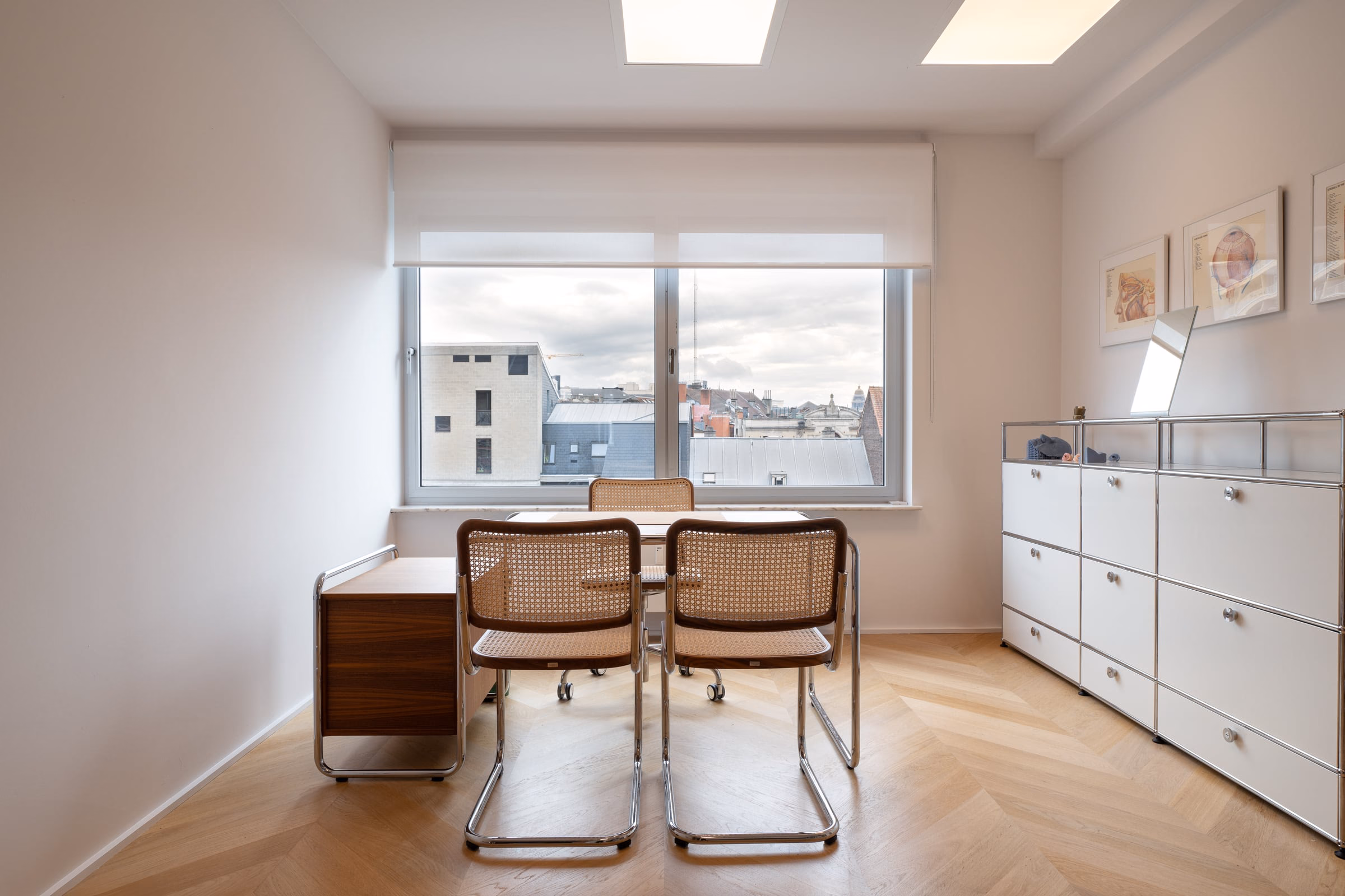 A room with a table, chairs and a window