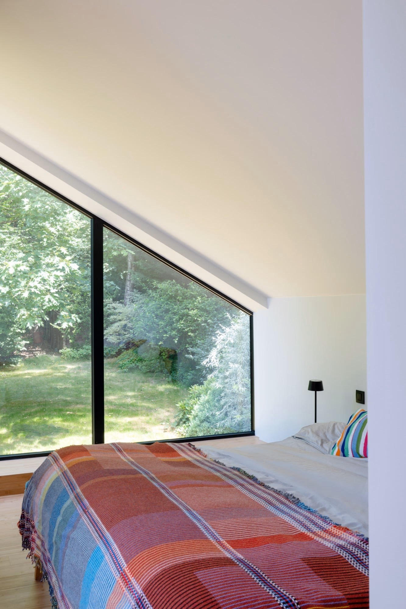 A bedroom with a bed and a large window