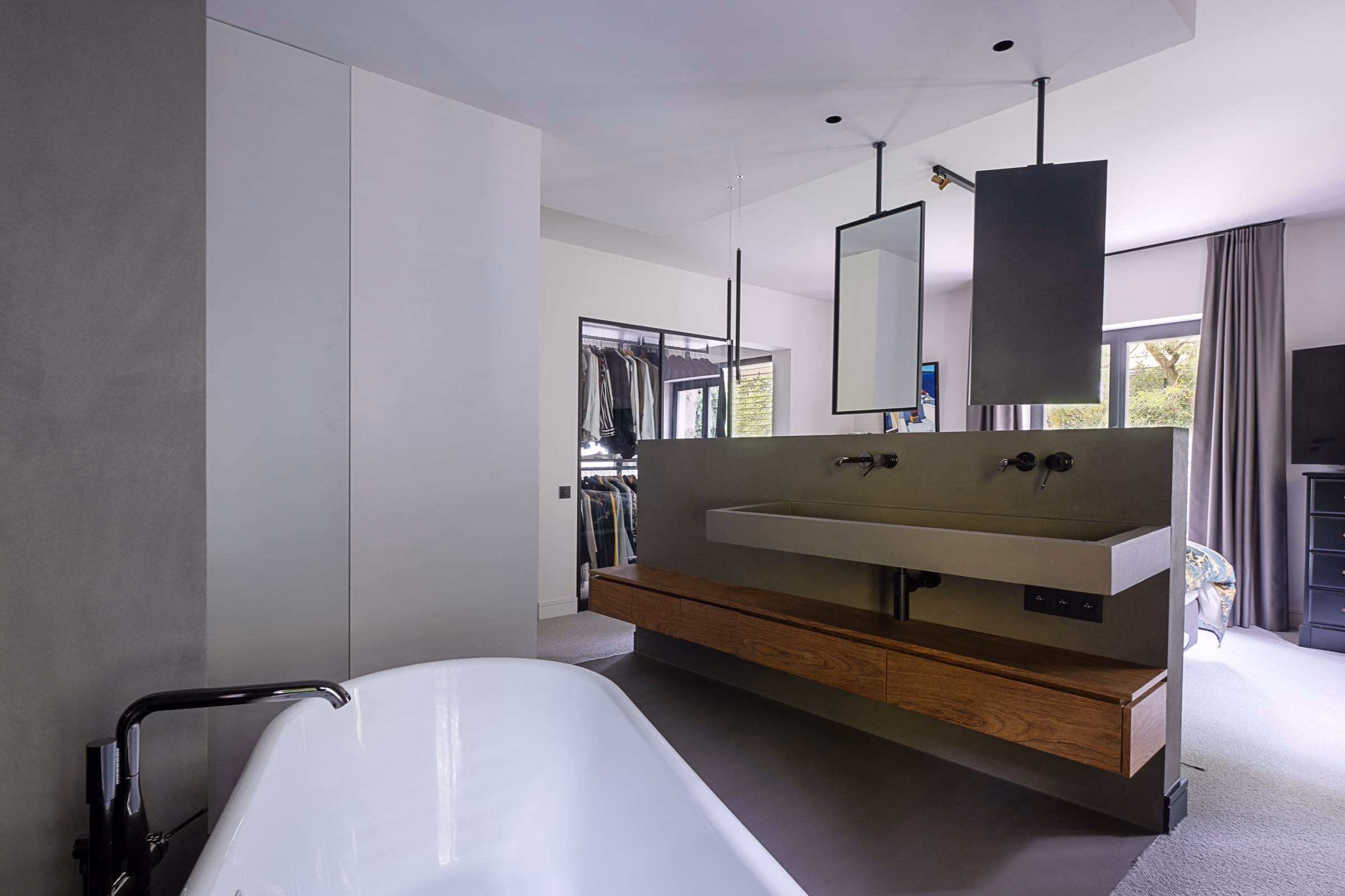 A bathroom with a bathtub, a washbasin and a mirror