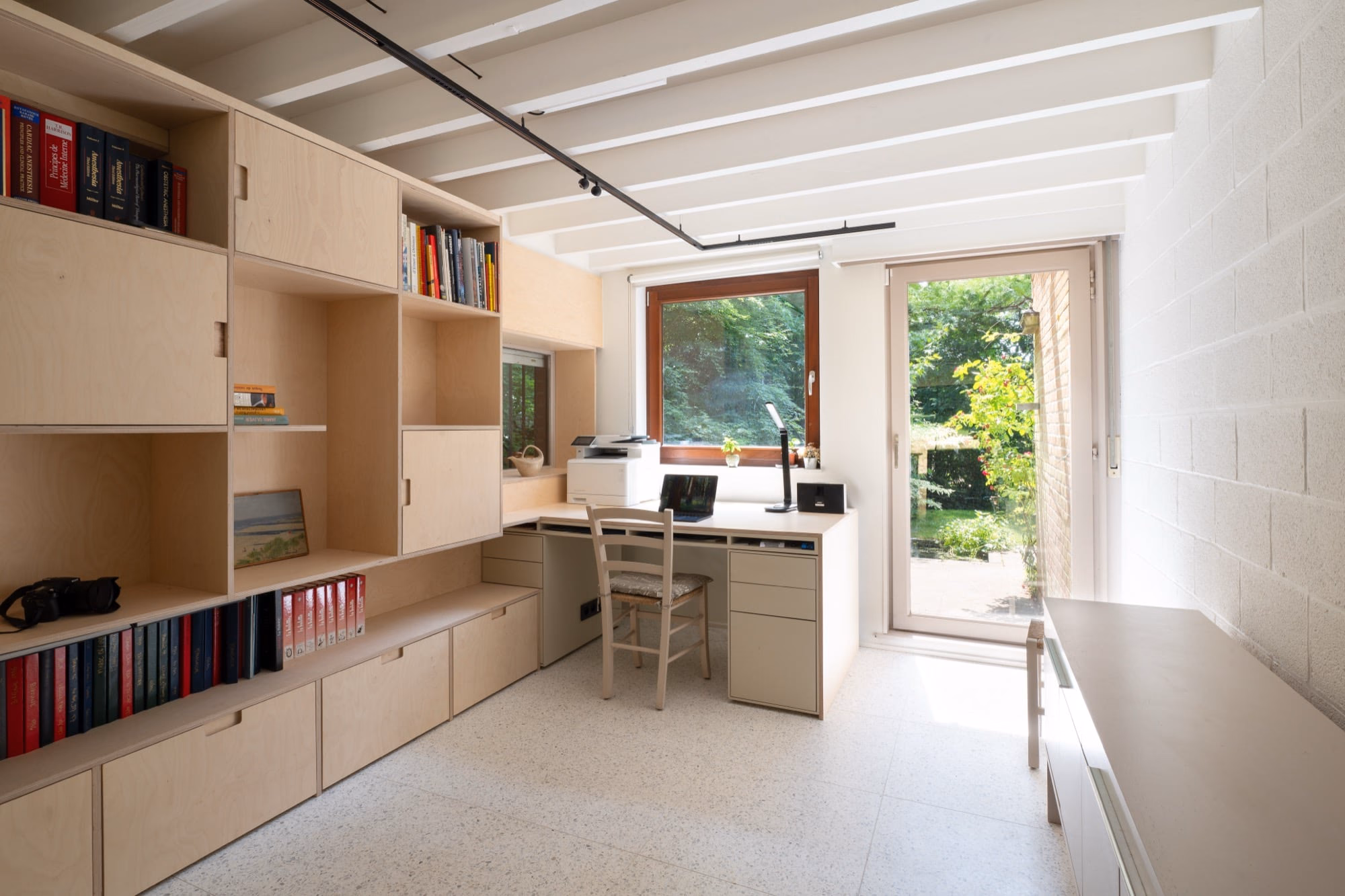 A room with a desk, a chair and a printer
