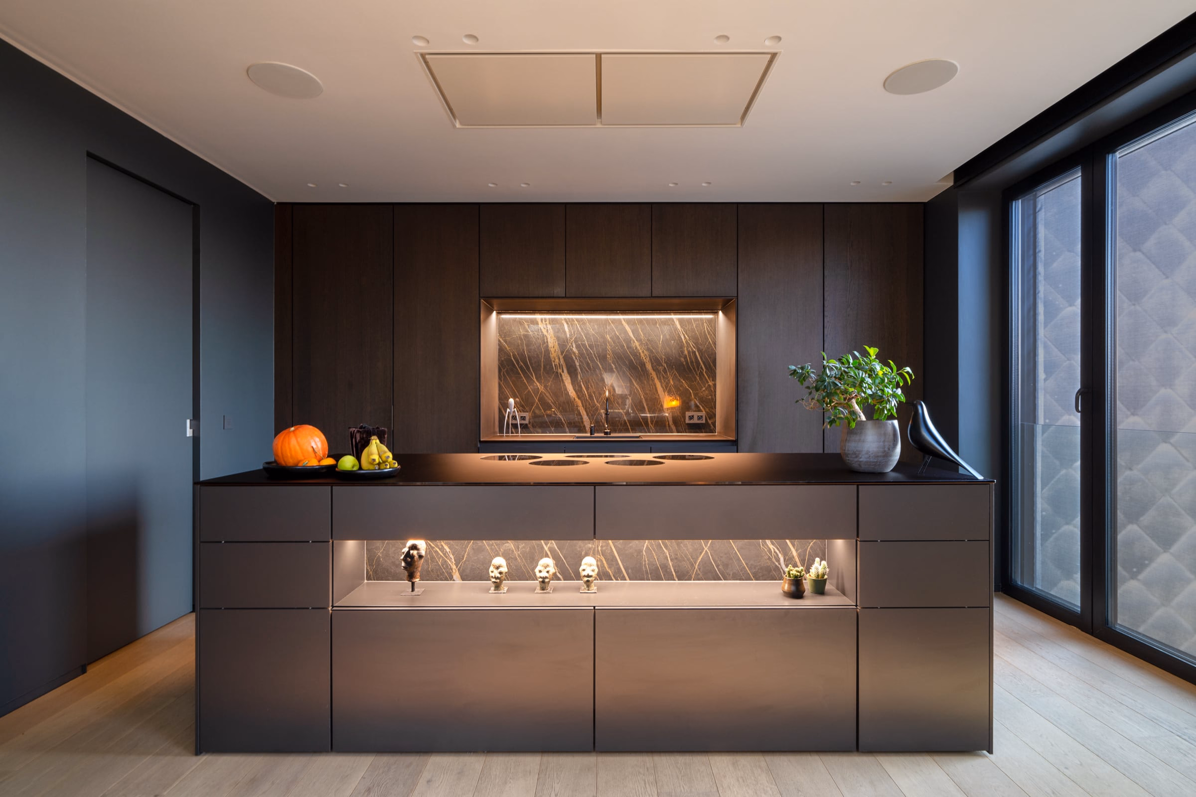 A kitchen with black cabinets and a marble worktop