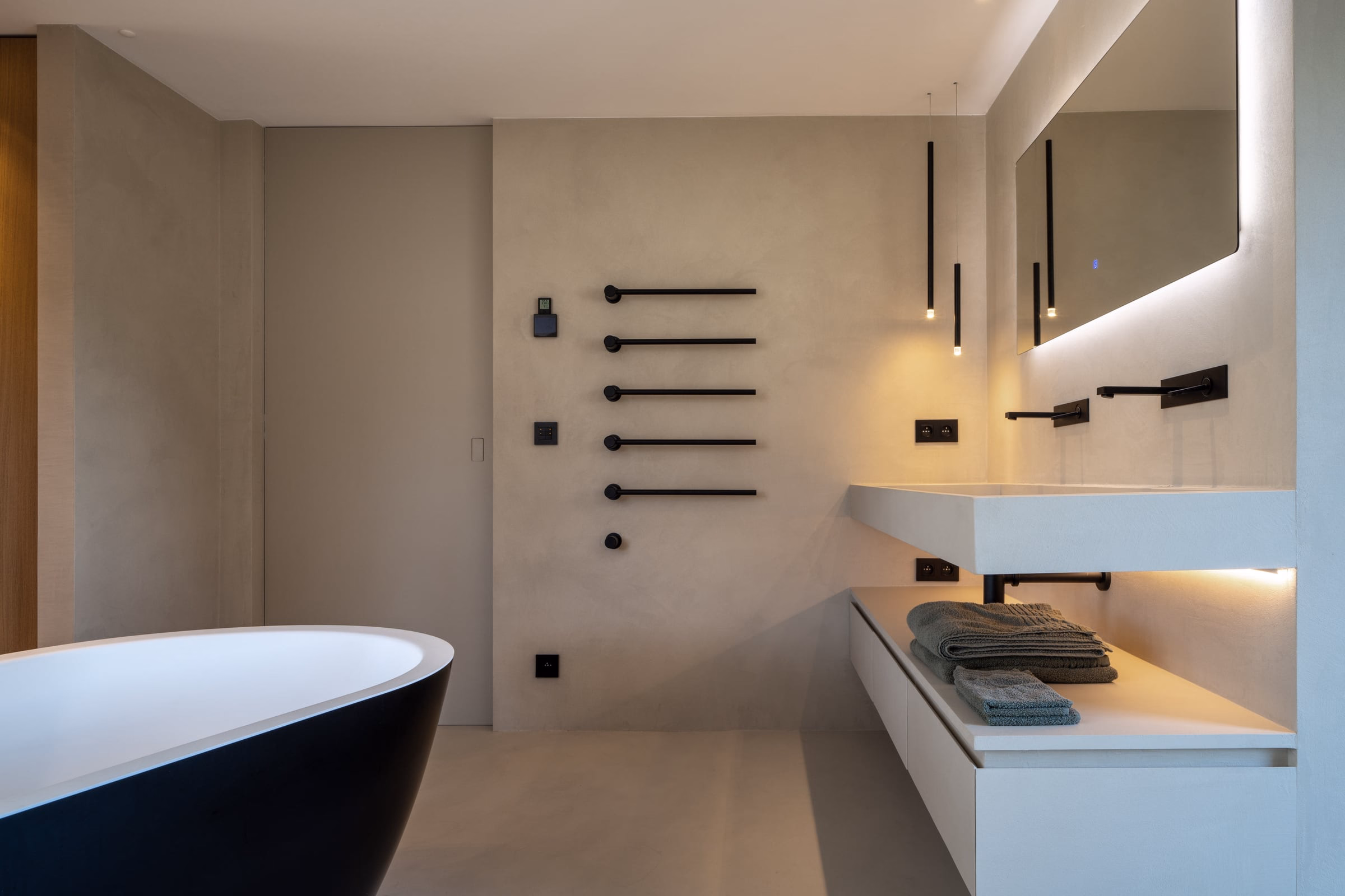 A bathroom with a black bathtub and a white washbasin