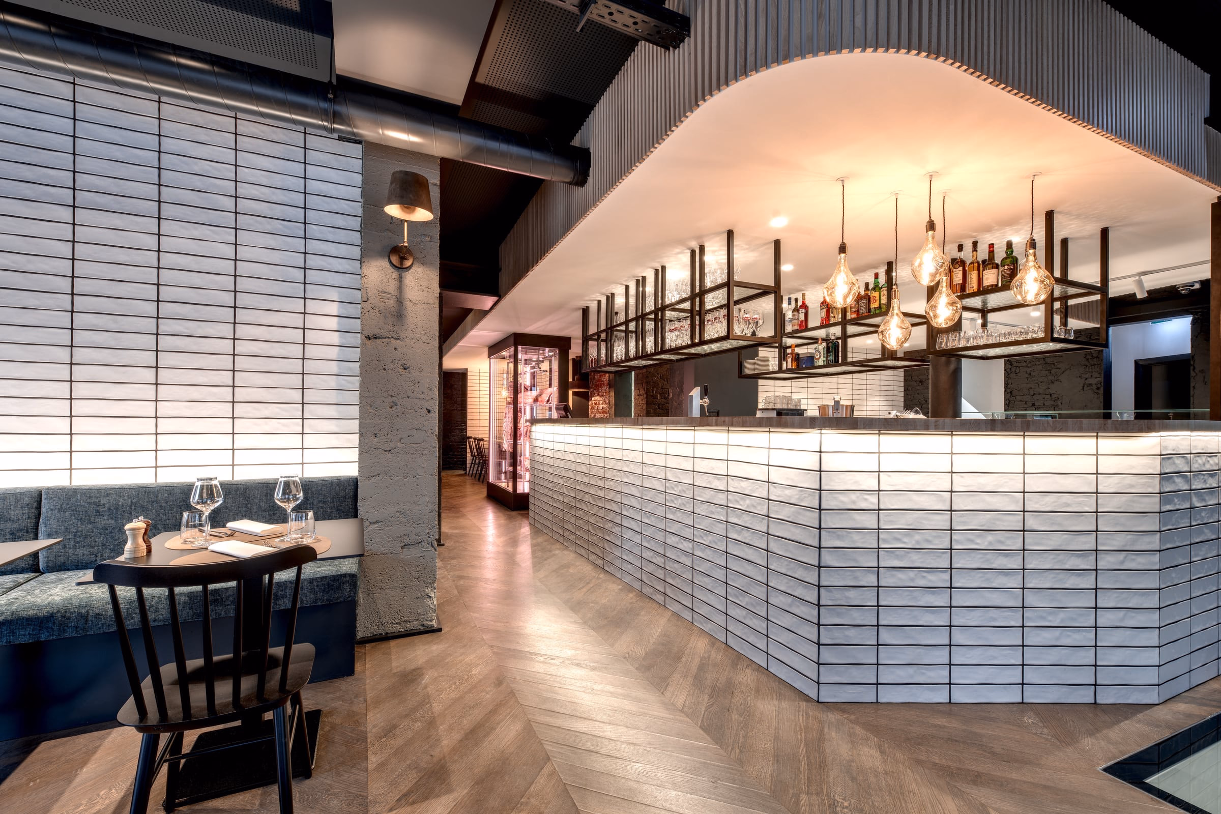 A restaurant with a long white counter and a bar